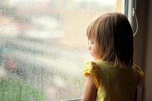 SINDROME DE TOURETTE Niña mirando por la ventana triste